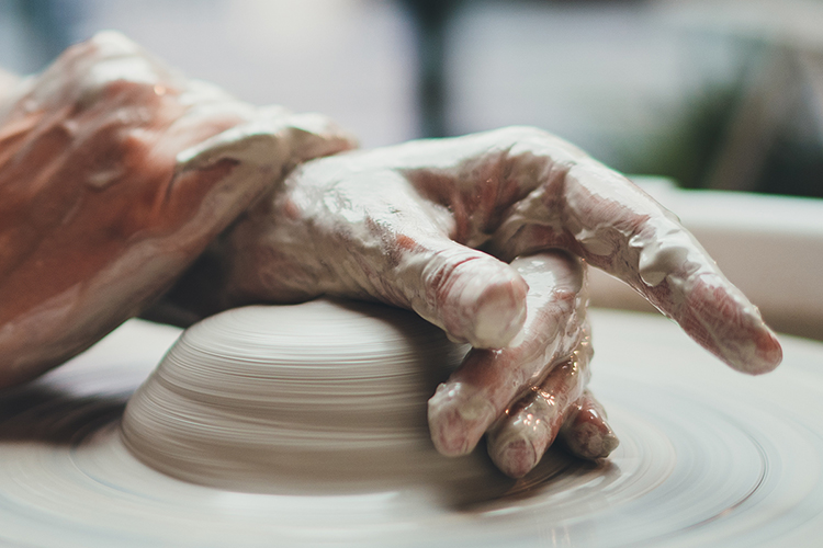 ceramicist working with clay on a wheel