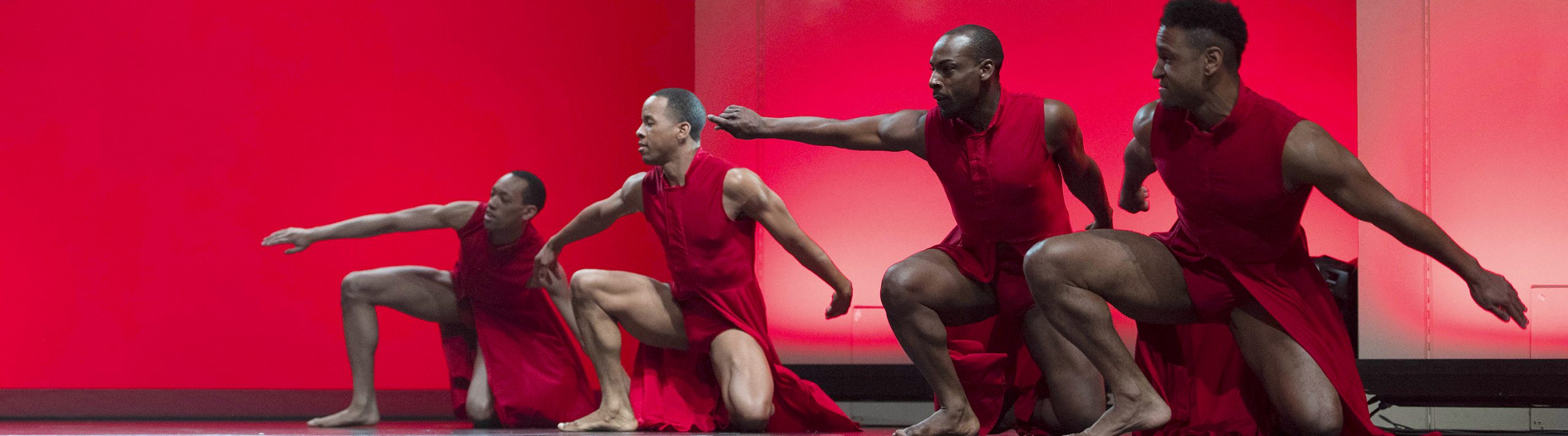 dancers in red on a stag performing