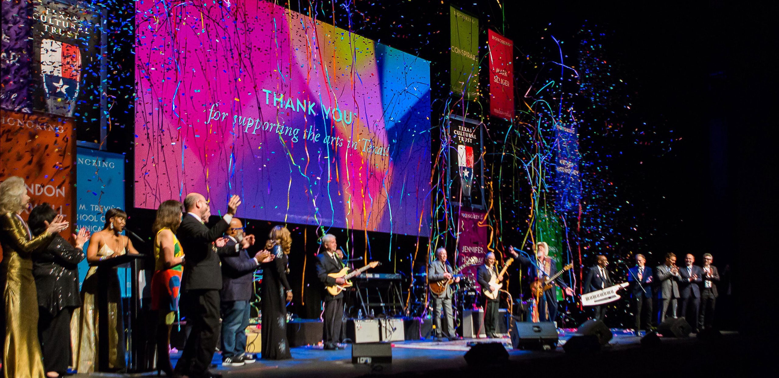 Confetti falls on a stage of honorees in thanks of supporting the arts in Texas
