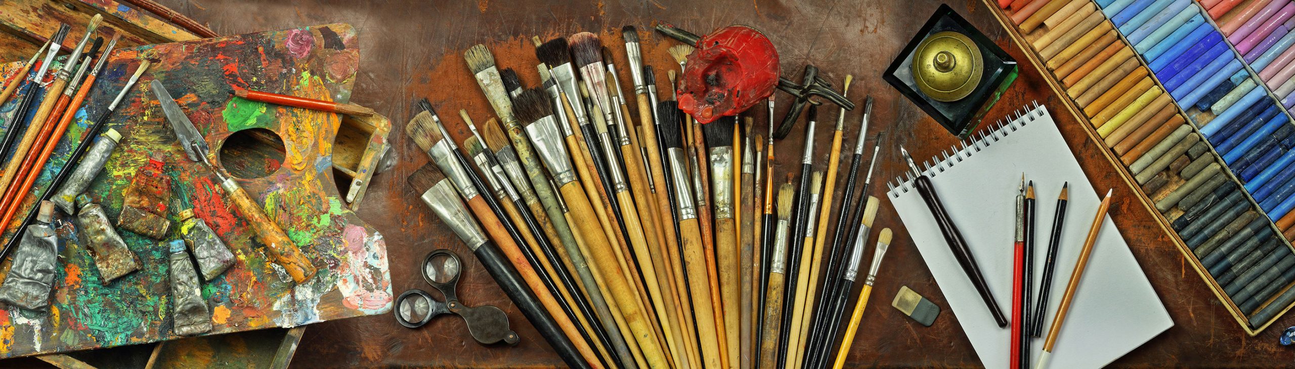 artist paintbrushes and supplies on a table