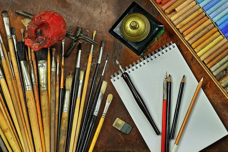 artist paintbrushes and supplies on a table